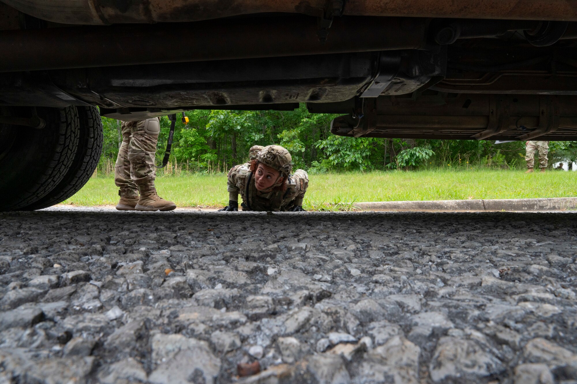 An Airman lays down and looks under a truck for simulated bombs.