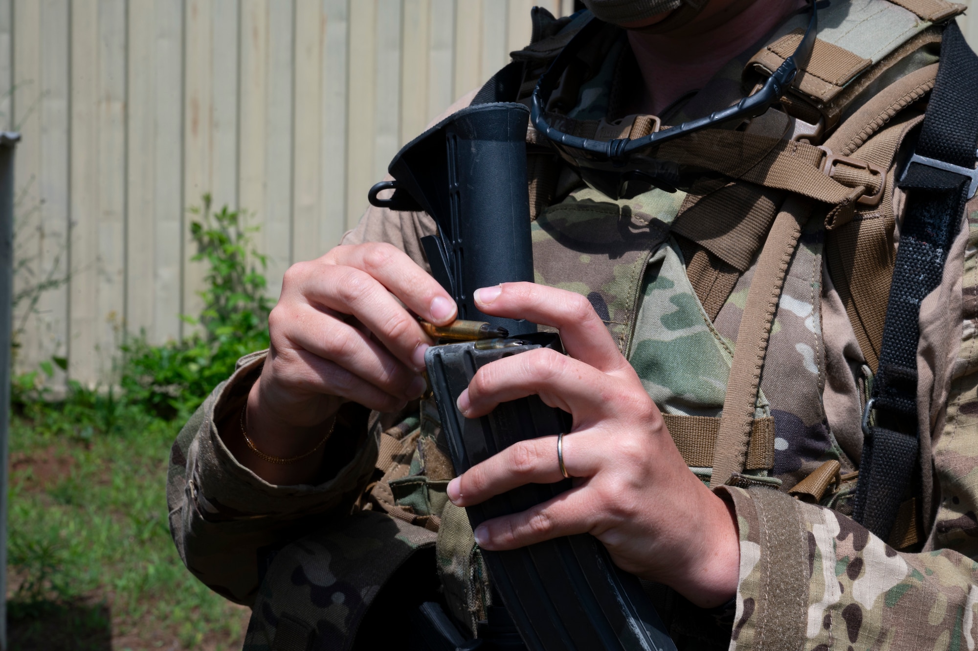 Hands are shown loading a bullet into a magazine.