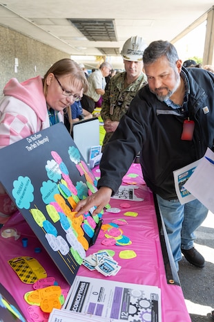 Patricia Ordway, Employee Anti-Harassment & Discrimination Team Employee Resource Group representative, assists Jaime Gutierrez, mechanical engineering technician-Instructor, Code 220.1, EPD Training, Process Management, Resources, and Radcon Controls, with a survey on reporting harassment claims May 21, 2024, during a Pathway to Safety campaign event at Puget Sound Naval Shipyard & Intermediate Maintenance Facility in Bremerton, Washington. (U.S. Navy photo by Wendy Hallmark)