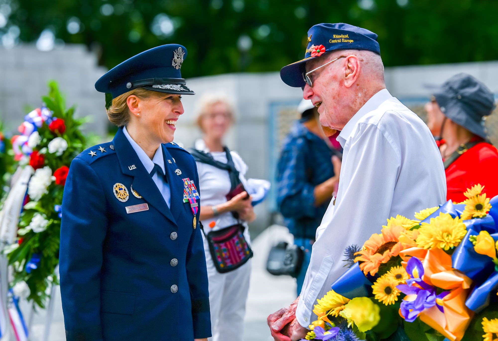 Woman in Air Force blues uniform speaks with elderly man