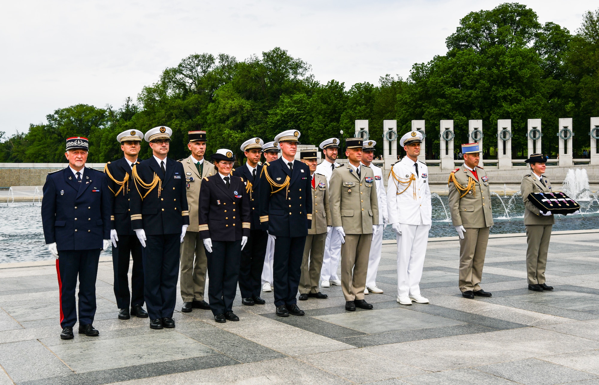French military members in uniform stand during the Victory in Europe ceremony