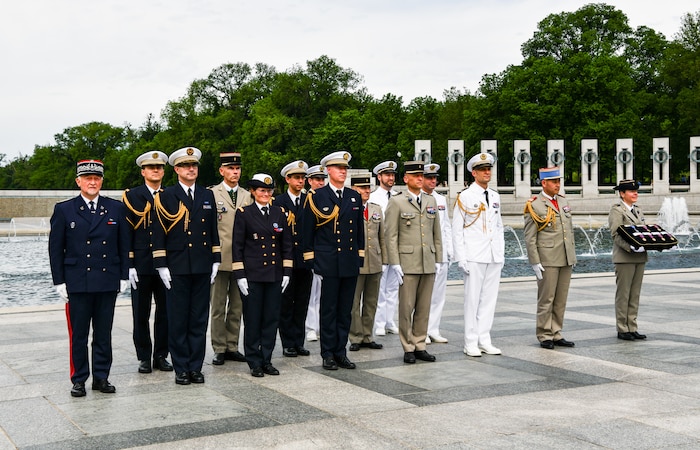 French military members in uniform stand during the Victory in Europe ceremony