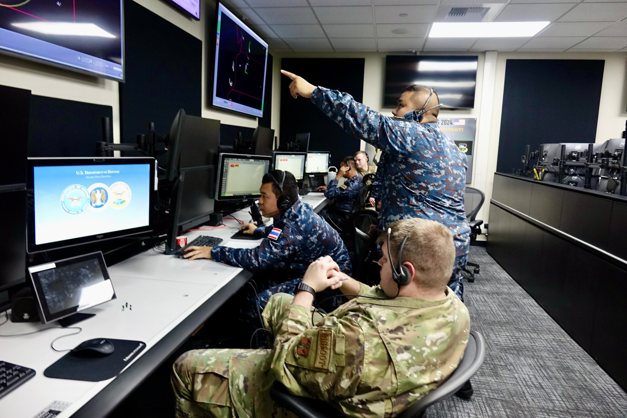 Airmen looking at computer screens.
