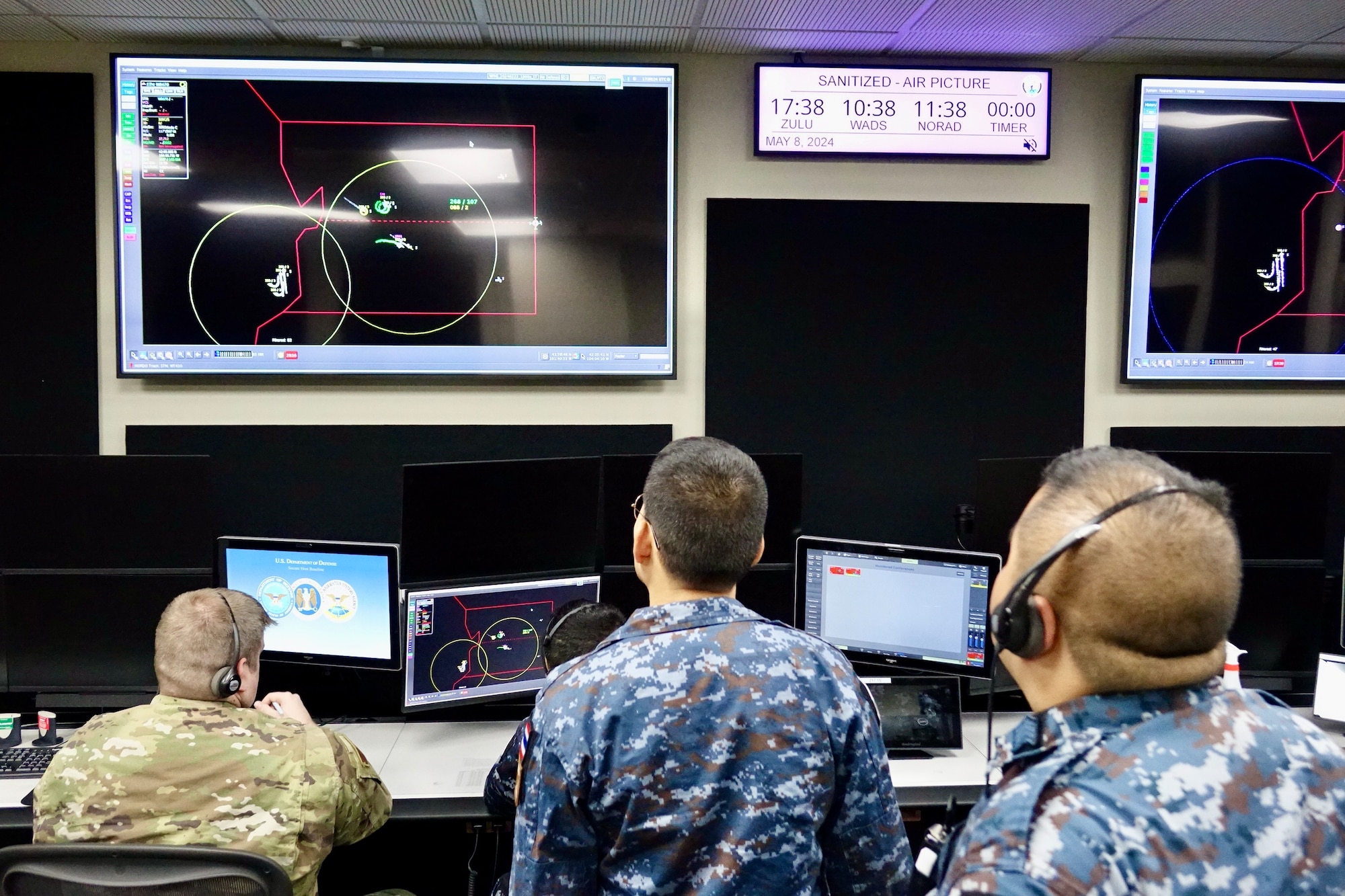 Airmen looking at computer screens.