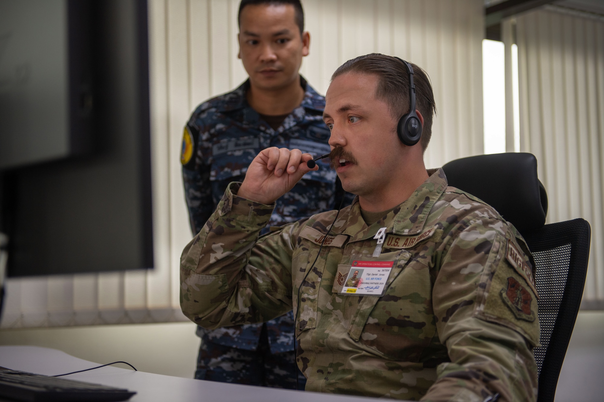 Airmen looking at computer screens