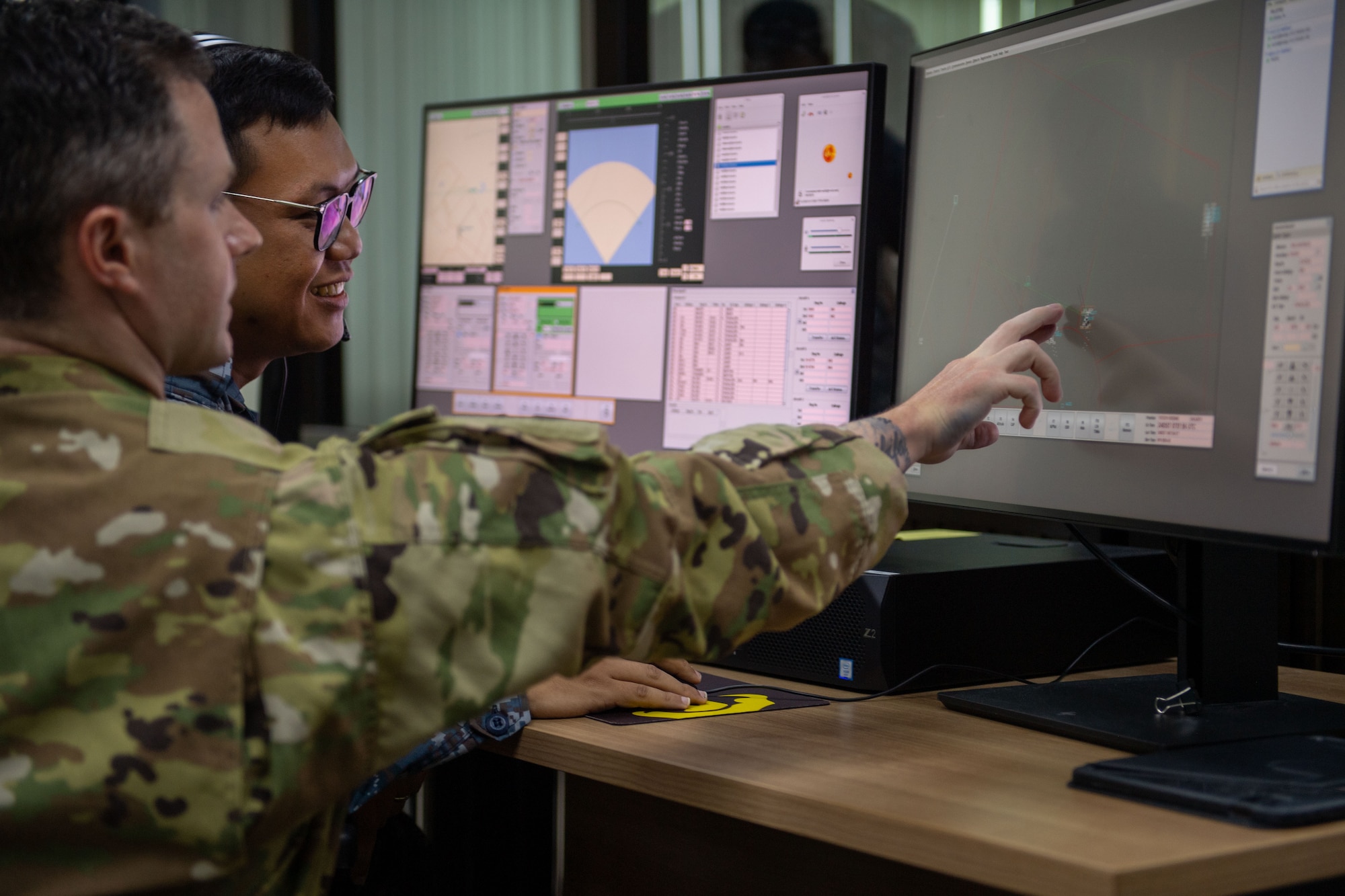 Airmen looking at computer screens.