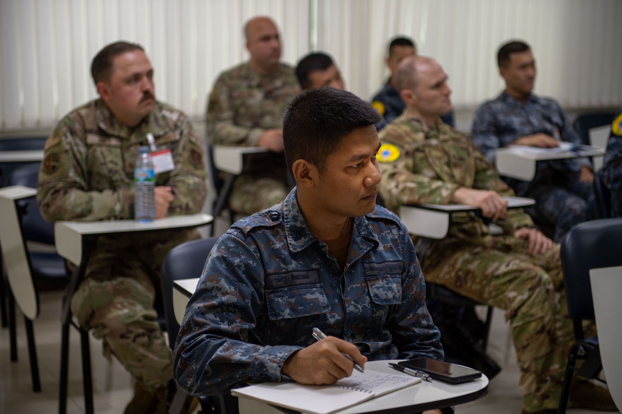 Airmen taking notes during a briefing
