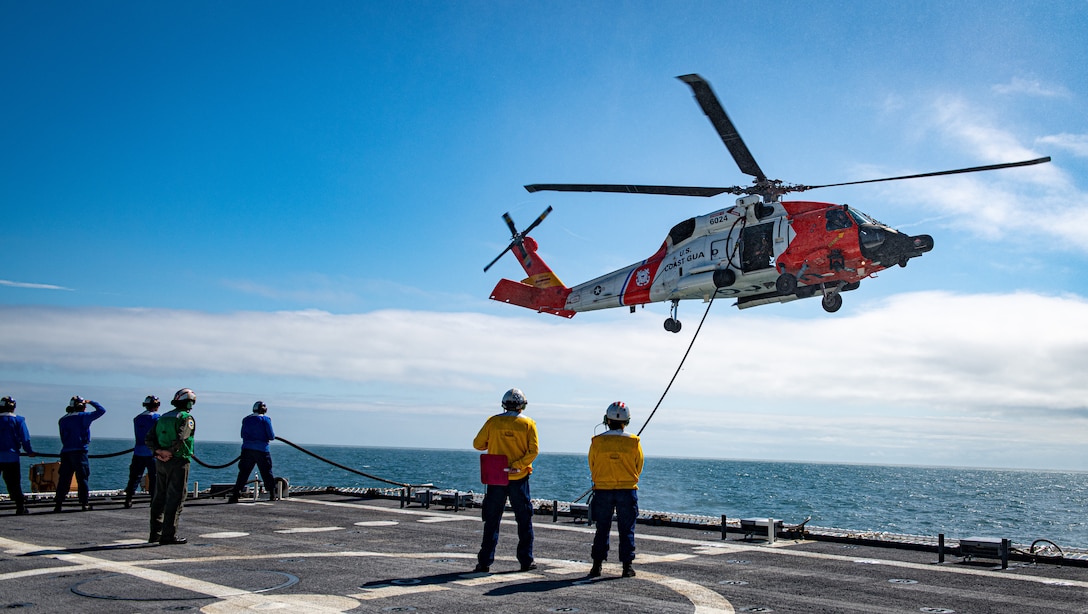 Crewmembers from the U.S. Coast Guard Cutter Calhoun (WMSL 759) conduct an in-flight refueling with an MH-60 helicopter crew from Coast Guard Air Station Elizabeth City offshore Norfolk, Virginia, May 16, 2024. This deployment is Calhoun's first support of fisheries enforcement in the North Atlantic. (U.S. Coast Guard photo by Lt. j. g. Adam Warren)