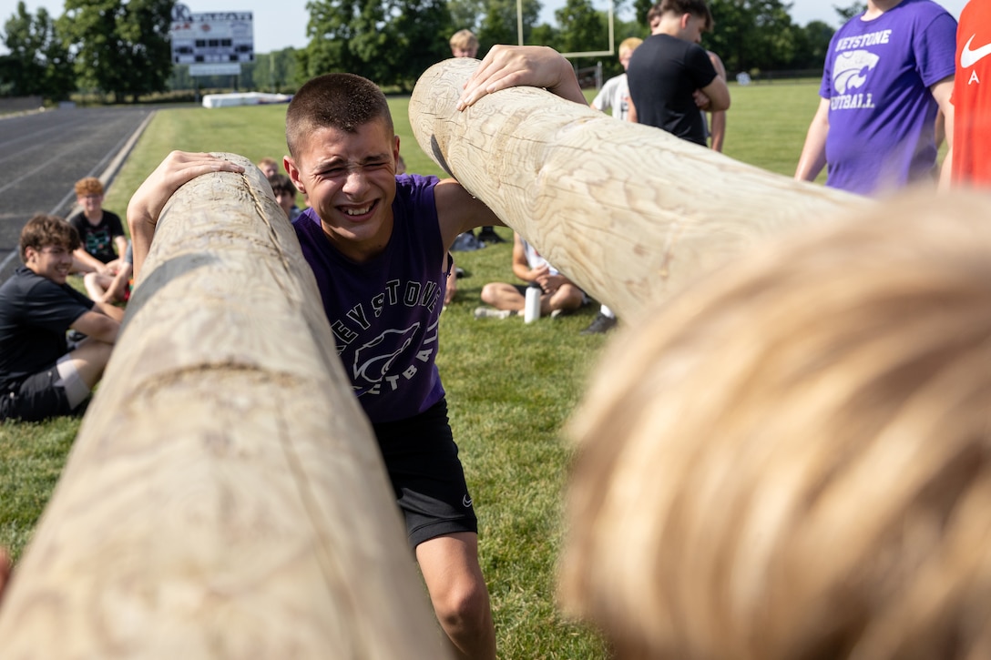 Troy Linden, a student at Keystone High School, holds up two logs to break a tie during a Spartan Fitness Challenge in Lagrange, Ohio, June 4, 2024. The Spartan Fitness Challenge connects recruiters with high school coaches to teach students about post-secondary career opportunities like the Marines by conducting workout-style activities with the students.  (U.S. Marine Corps photo by Sgt. Austin Molla)