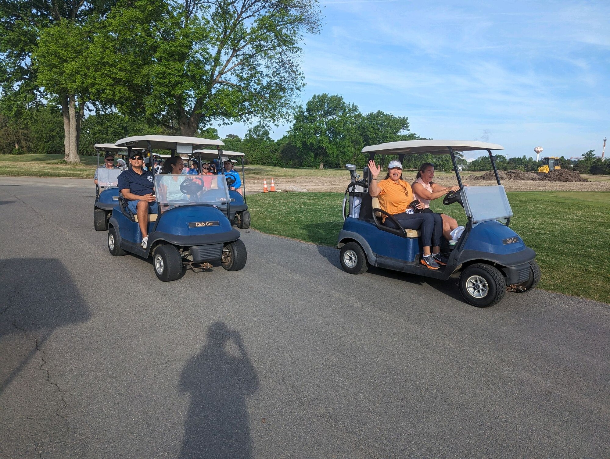 Three golf carts with people in them driving down the road.