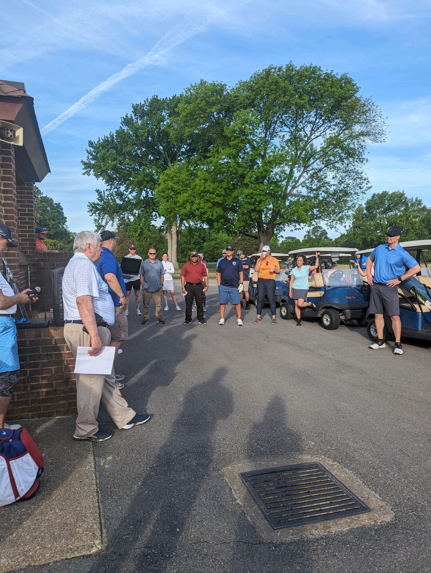 People standing around listening to speaker give instructions.