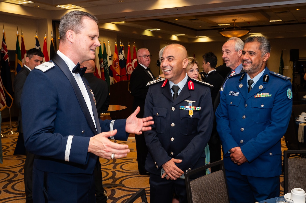 Three men talk during the AFSAC/FLO International reception