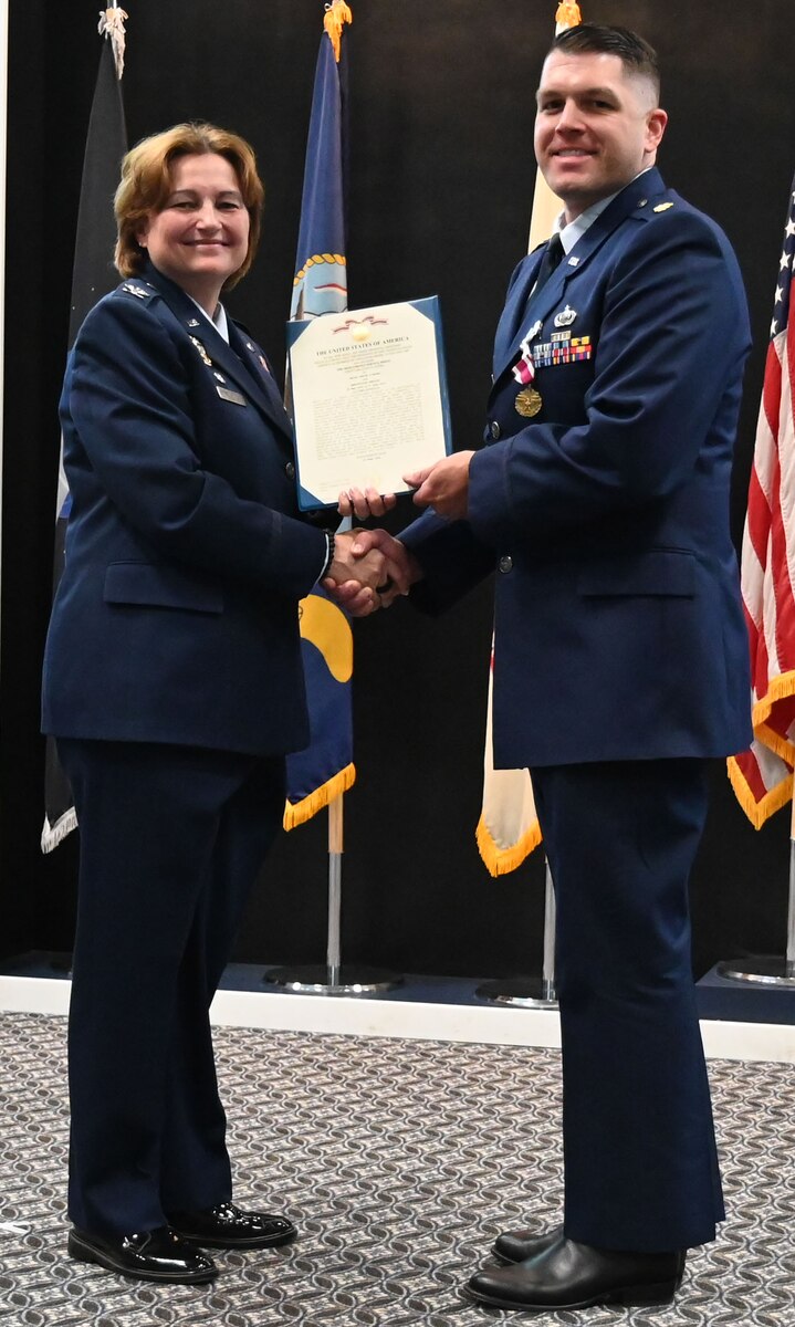 U.S. Air Force Col. Angelina Maguinness, 17th Training Wing commander, presents Maj. Justin Moore, outgoing 17th Comptroller Squadron commander with a meritorious service medal, during the change of command ceremony at the Powell Event Center, Goodfellow Air Force Base, Texas, June 4, 2024. The Meritorious Service Medal is a military award given to members of the United States Armed Forces for their outstanding service or achievements. (U.S. Air Force photo by Staff Sgt. Nathan Call)