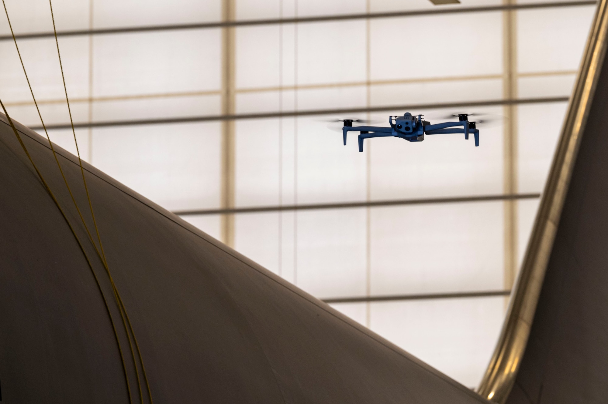 A Skydio X10D drone hovers next to a KC-46A Pegasus May 29, 2024, at McConnell Air Force Base, Kansas. The X10D is an autonomous drone that utilizes computer vision to build a 3D model of its environment to navigate and conduct scans without user input. (U.S. Air Force photo by Airman 1st Class Gavin Hameed)