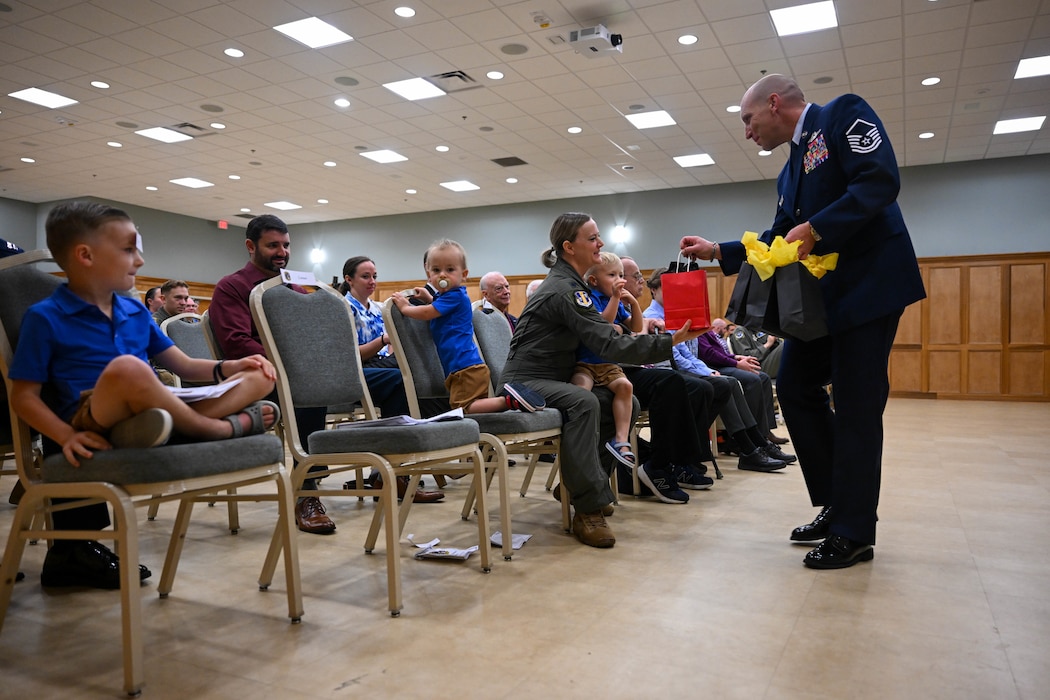 An Airman hands gifts to family members