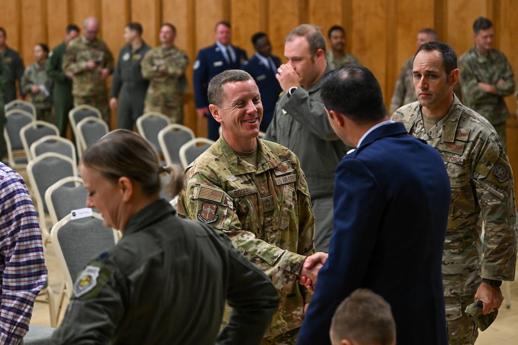 An Airman shakes hands with a commander