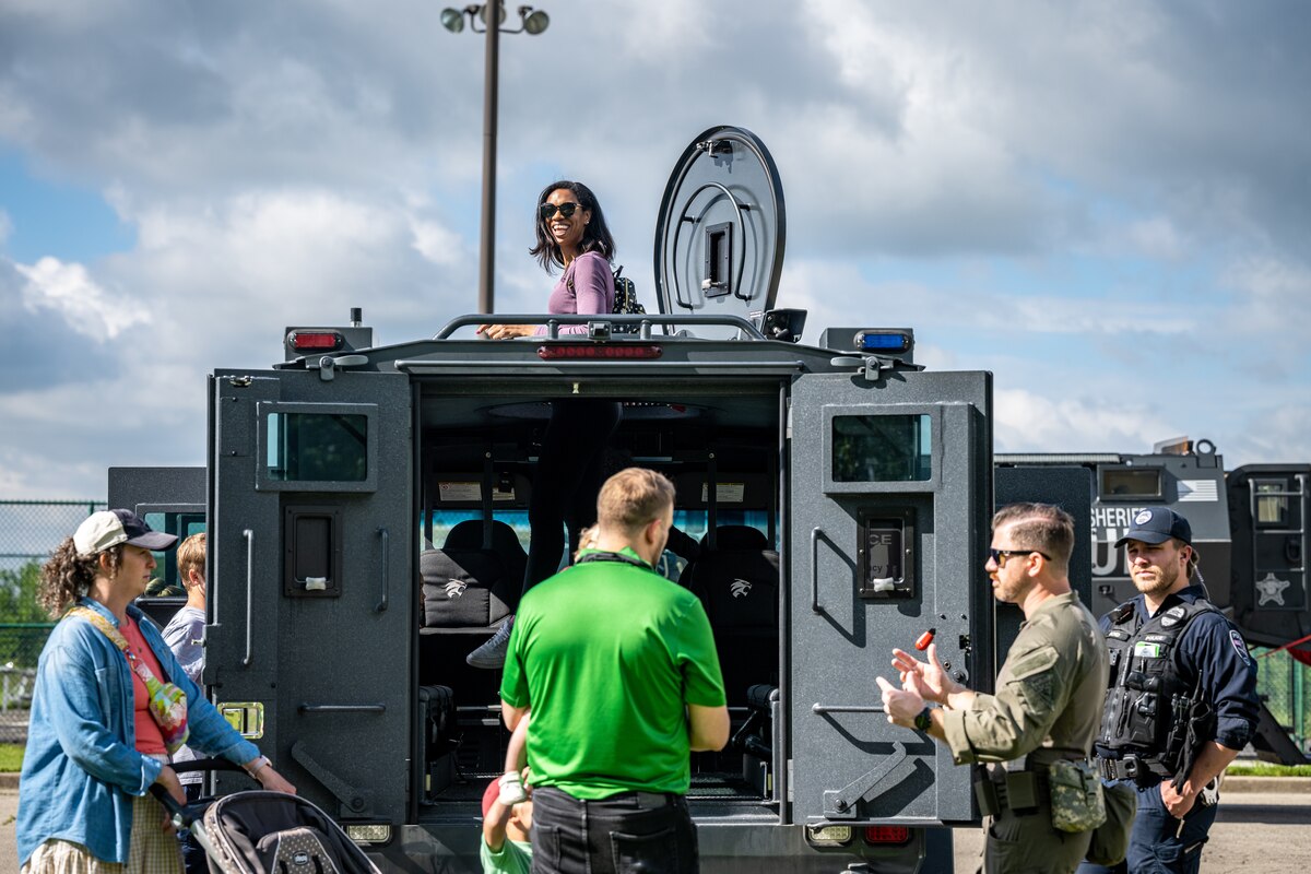 Attendees look inside a tactical police vehicle
