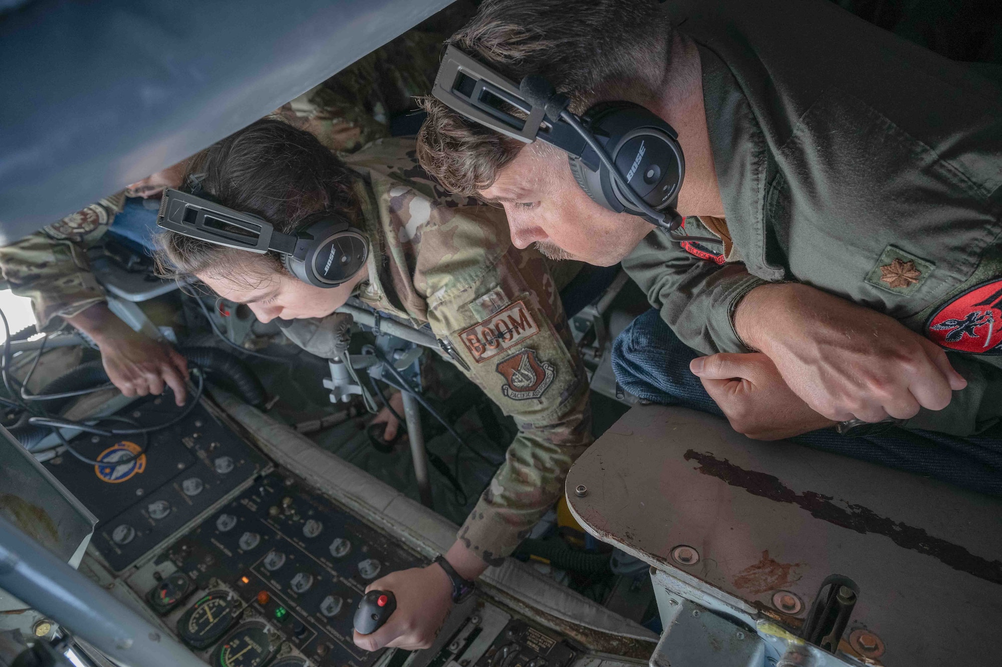 U.S. Air Force Airmen assigned to the 909th Air Refueling Squadron and 27th Fighter Squadron observe F-22A Raptors conduct aerial refueling with a KC-135 Stratotanker.