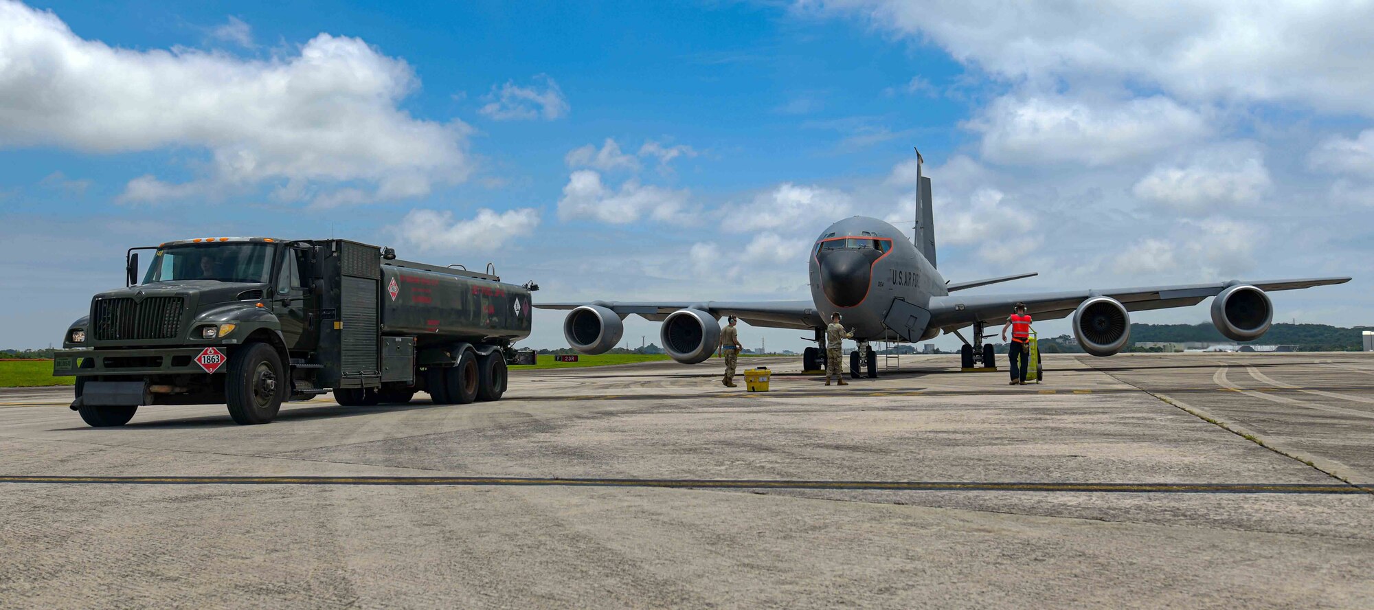 A fuel tanker leaves the runway after a hot-pit refuel on a KC-135 Stratotanker.
