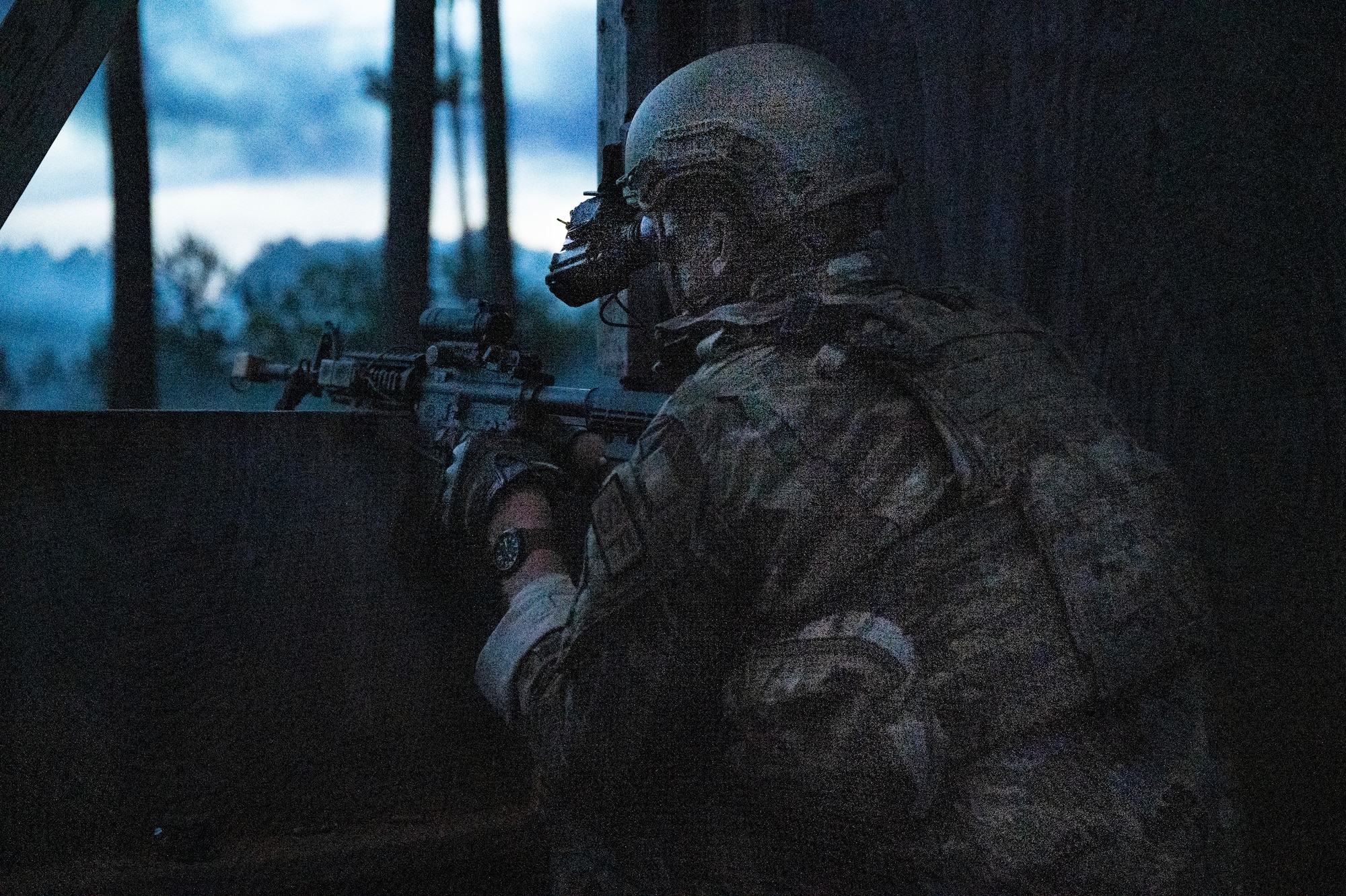 An Airman mounts his weapon on window, returning fire.