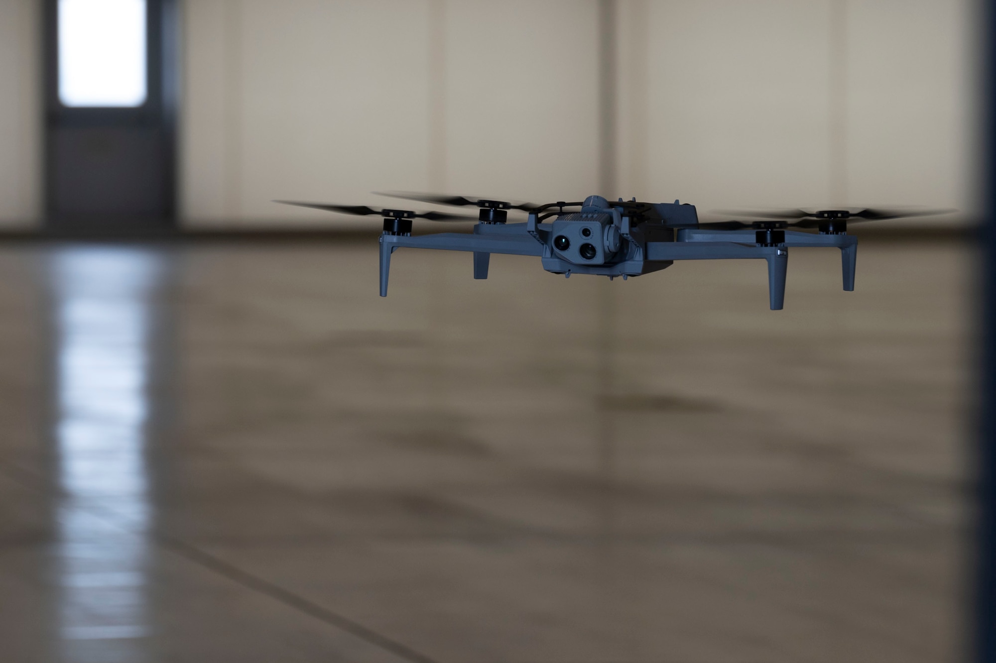 A Skydio X10D drone hovers inside a hanger May 29, 2024, at McConnell Air Force Base, Kansas. The drone utilizes computer vision to construct a 3D model of its surroundings, allowing it to navigate independently and perform scans without manual control. The scan is then imported into software that uses AI to identify defects, anomalies, delamination, and inspection issues on aircraft. (U.S. Air Force photo by Airman 1st Class Gavin Hameed)