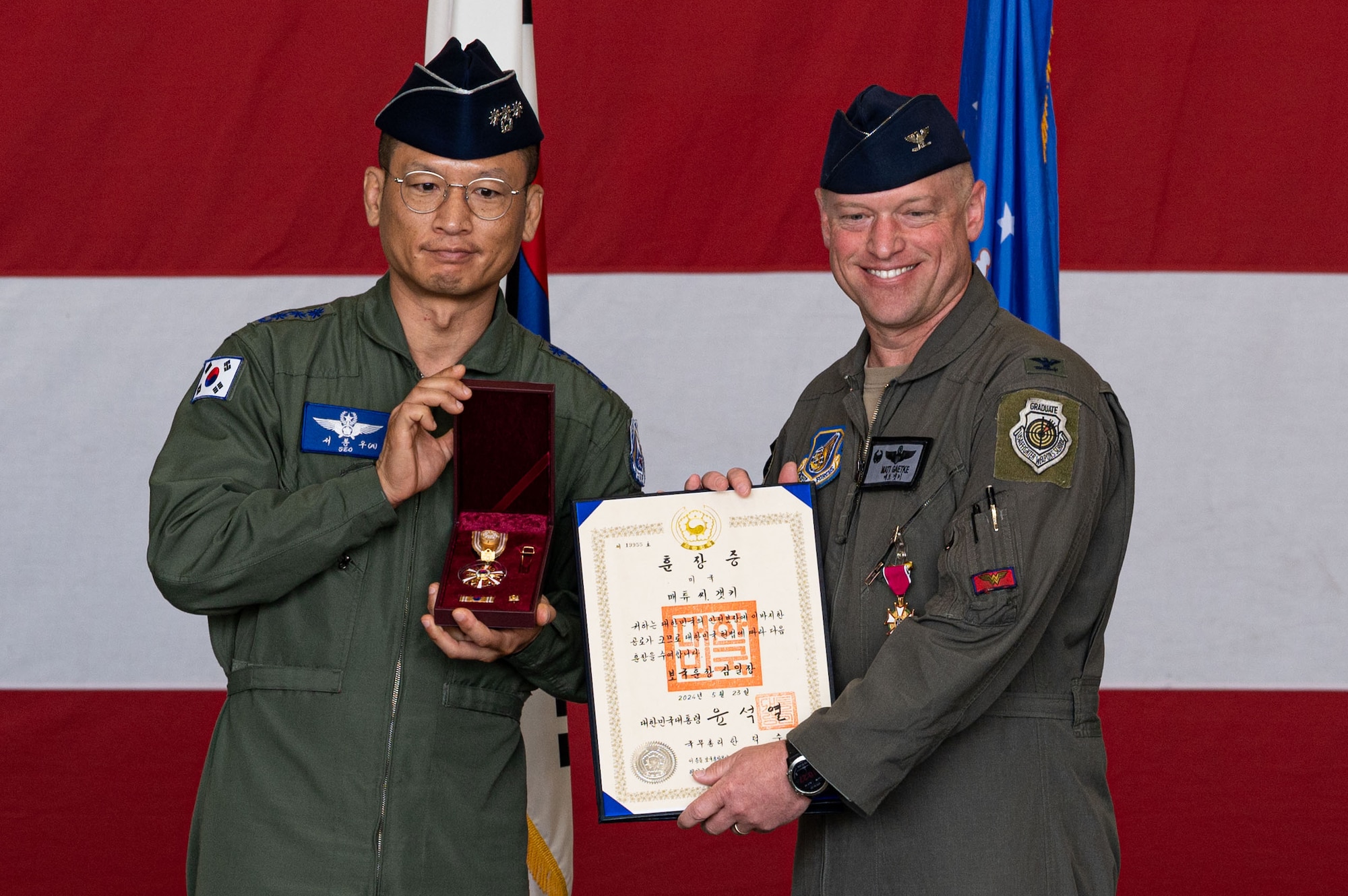 U.S. Air Force Col. Matthew Gaetke, 8th Fighter Wing outgoing commander, receives the Republic of Korea, Order of the National Security Merit Samil medal from ROK Air Force Col. Seo, Dong Woo, 38th Fighter Group commander, during the 8th FW change of command ceremony.