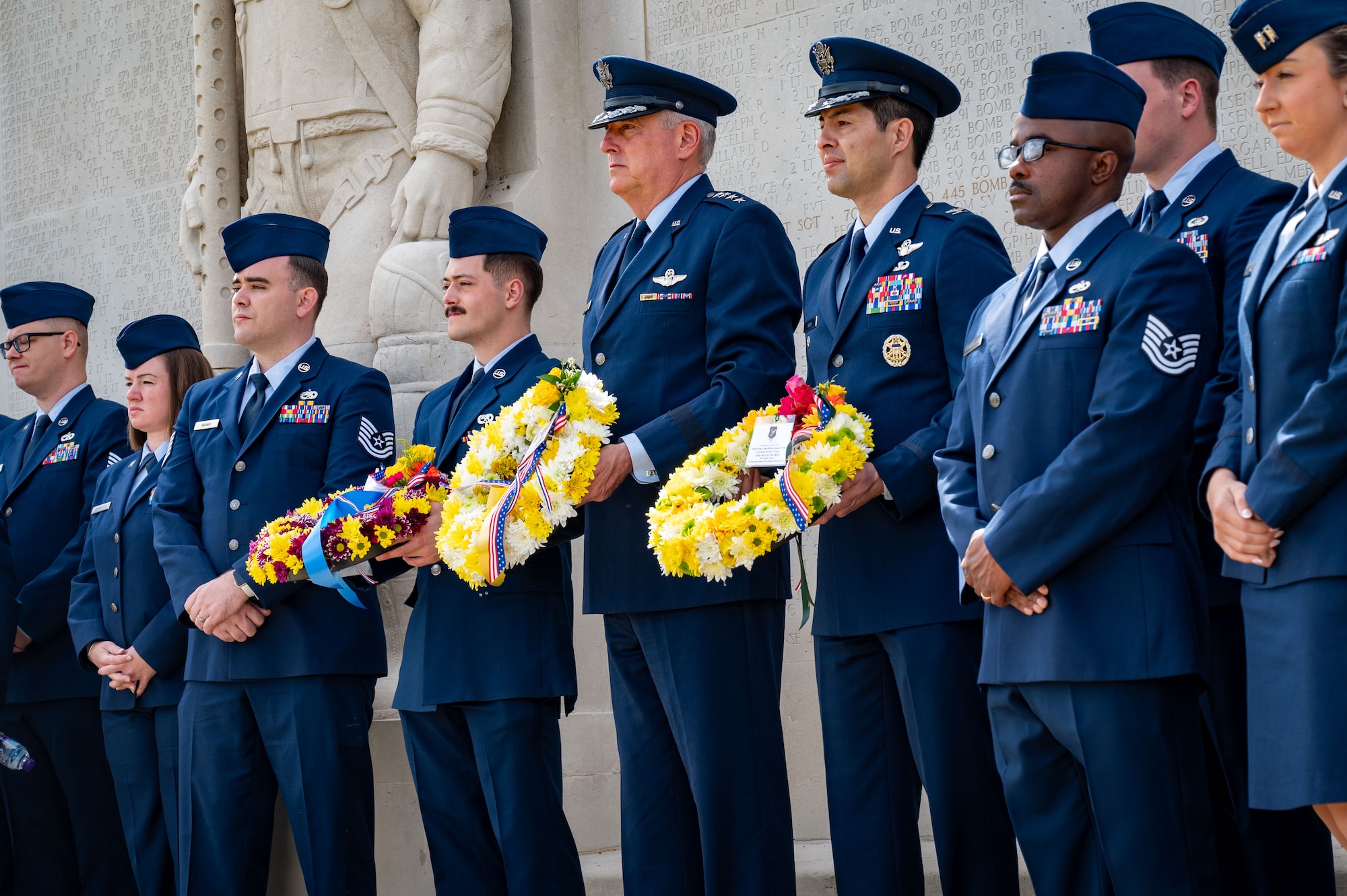 U.S. Air Force Gen. Mike Minihan, commander of Air Mobility Command, Col. William Soto, 305th Air Mobility Wing deputy commander, and U.S. Air Force Senior Airman Joshua Schmoyer, 605th Aircraft Maintenance Squadron maintainer, prepare to lay commemorative wreaths in honor of the 305th Bombardment Group fallen Airmen during the Memorial Day Ceremony at the Cambridge American Cemetery, England, May 27, 2024. The 305th AMW hosted its heritage trip for the third consecutive year to learn about its forebearer, the 305th BG, who was crucial to the nation’s triumph against Nazi Germany in World War II. (U.S. Air Force photo by 2nd Lt. Alexis Kula)