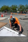 a contractor installs a white flexible sheet with light emitting diodes into a star point triangle at the base of the U.S. Air Force Memorial