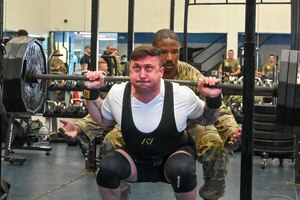 U.S. Air Force Staff Sgt. Dean Dorf, community engagement officer for the 11th Security Forces Squadron, squats with 315 pounds of weight during the police week powerlifting competition at the fitness center on Joint Base Anacostia-Bolling, Washington, D.C., May 16, 2024. There were more than 25 participants who showed up to compete in the challenge. (U.S. Air Force photo by Airman Shanel Toussaint)