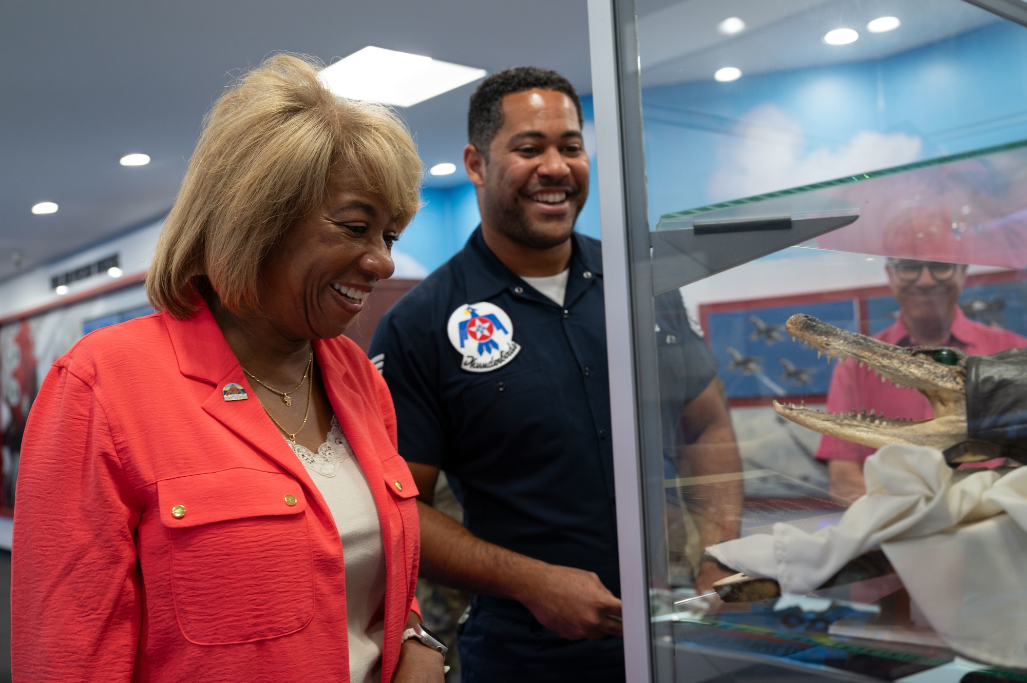 A man and a woman stand in front of a display case