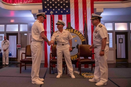 Rear Admiral Max McCoy, commander, Carrier Strike Group Four (CSG-4), middle, shakes hands with Capt. Sean Anderson, left, as he is relieved of command at Tactical Training Group Atlantic (TTGL)'s change of command ceremony.