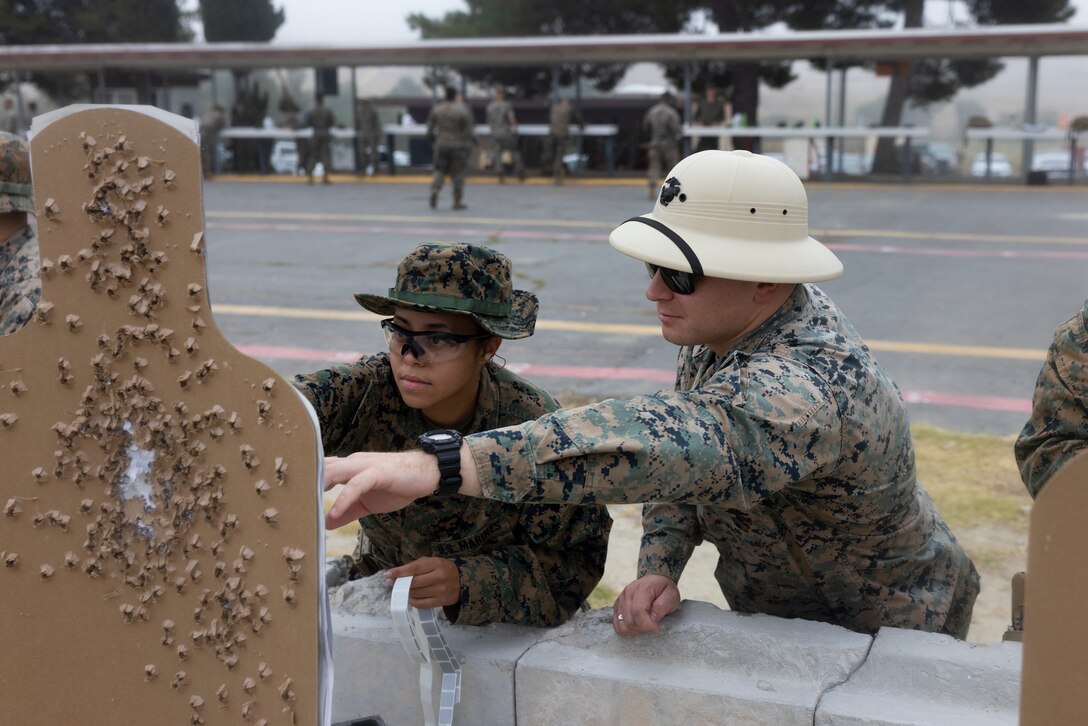 U.S. Marine Corps Sgt. Anabel Abreu, left, a combat photographer with 1st Communication Strategy and Operations Company, I Marine Expeditionary Force Information Group, reviews her shots with Sgt. Julian Mangold, a combat marksmanship coach with 1st Radio Battalion, I MIG, during an annual pistol qualification at Marine Corps Base Camp Pendleton, California, Aug. 15, 2023. Marines with I MIG conduct pistol training to enhance their lethality and maintain warfighting readiness; remaining the world’s most capable and mobile fighting force able to respond anywhere at any time. (U.S Marine Corps photo by Sgt. Nicolas Atehortua)