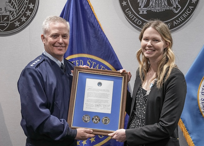Gen. Timothy D. Haugh, commander U.S. Cyber Command,  presents Ms. Holly Baroody with a star note in honor of Ms. Baroody's tenure with U.S. Cyber Command.