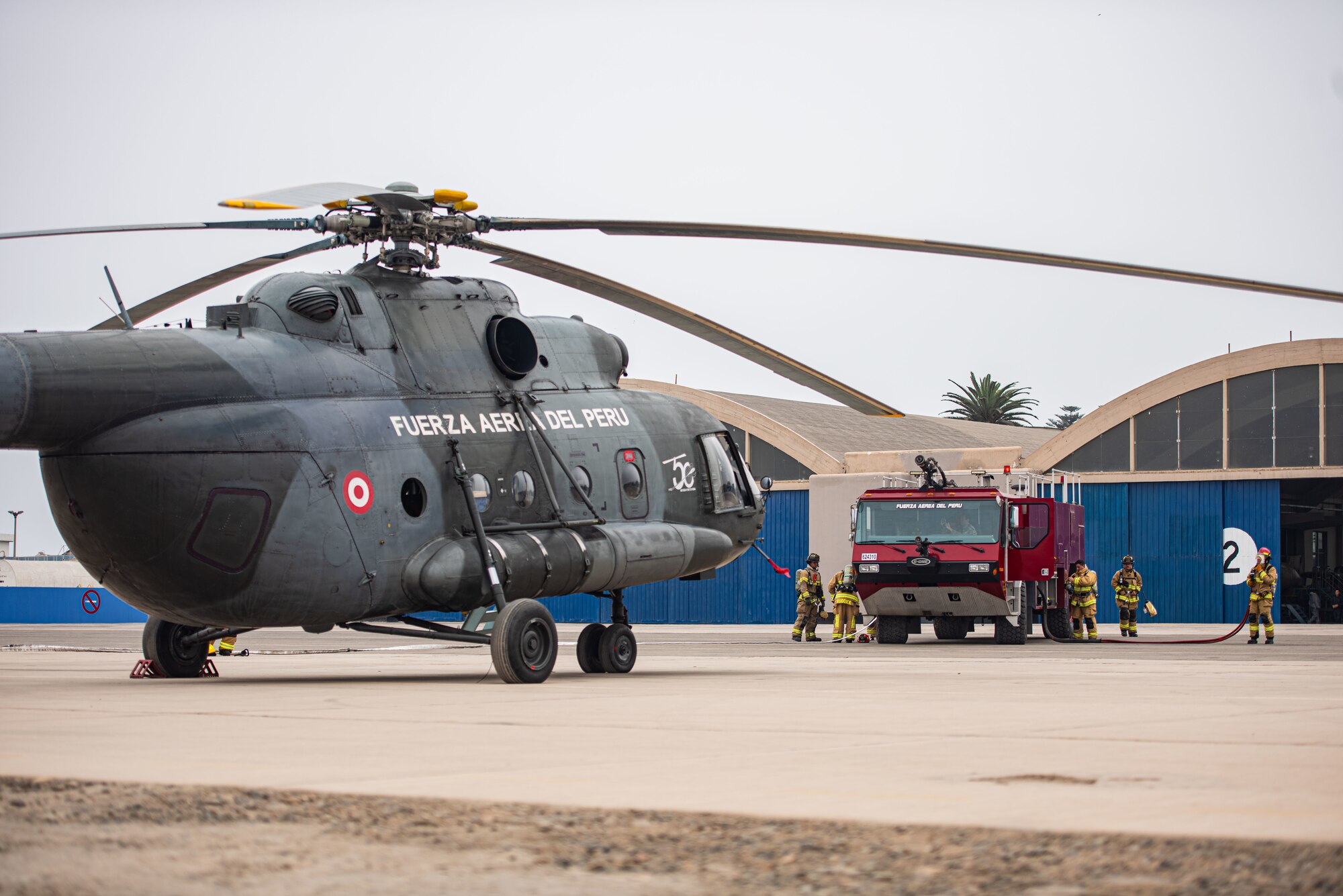Peruvian and U.S. Air Force firefighters stage a simulated MIL Mi - 17 helicopter fire for a fire rescue evacuation training during Resolute Sentinel 2024 in Lima, Peru, June 3, 2024. Exercise RS24 is an opportunity for cultural and tactical integration between the U.S. and its allied partnered nations. (U.S. Air force photo by Airman 1st Class Sir Wyrick)