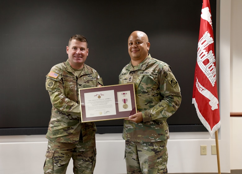 U.S. Army Corps of Engineers, Savannah District Commander Col. Ronald Sturgeon (left) presents U.S. Army Master Sgt. Shermaine Malone, a contract specialist with the District with the Meritorious Service Medal in recognition for his service to the District, May 29, 2024, during a retirement ceremony at the District headquarters in Savannah, Georgia.