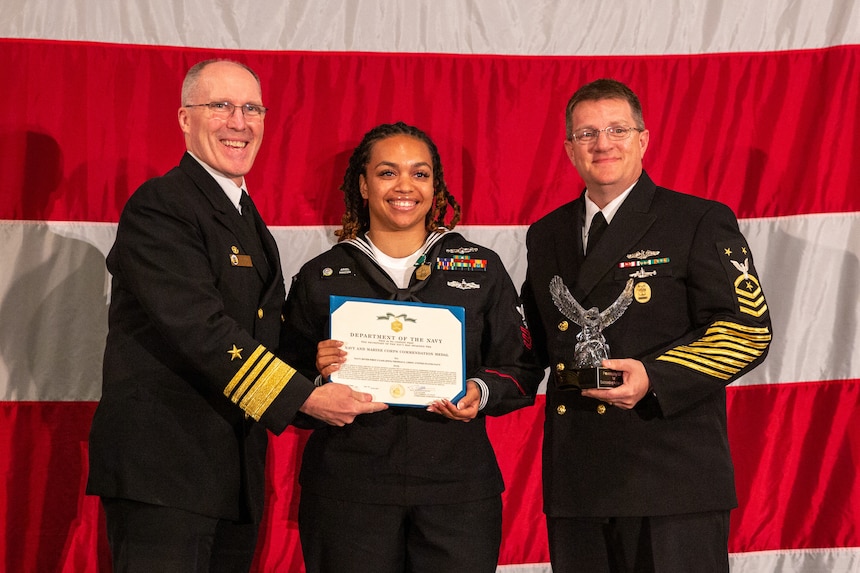 NORFOLK, Va. (June 6, 2024) Vice Adm. Robert Gaucher, commander, Submarine Force Atlantic, and Force Master Chief Neil Ford, Submarine Force Atlantic, present the Navy and Marine Corps commendation medal to Intelligence Specialist 1st Class Ariel Macon during the 2024 USFFC Sailor of the Year announcement dinner, June 6th 2024. The dinner is the culmination of a weeklong series of events that concludes with the announcement of the 2023 sea and shore Sailors of the Year. Sea and Shore Sailors of the Year will be meritoriously advanced to chief petty officer. (U.S. Navy photo by Mass Communication Specialist 1st Class Evan Thompson/Released)