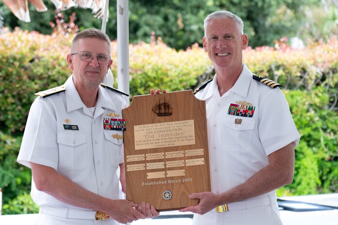 Vice Adm. Johnny Wolfe Jr., director of U.S. Navy Strategic Systems Programs (SSP) (left) is recognized with the Navy's 'Old Ironsides' plaque by Capt. Neil Sexton, Engineering Duty Officer (EDO) Schoolhouse commander (right), during the school's fiftieth anniversary luncheon Thursday, June 6. SSP is the Navy command that provides cradle-to-grave lifecycle support for the sea-based leg of the nation's nuclear triad and for approximately 70 percent of the U.S.'s deployed strategic nuclear assets. EDOs supporting SSP are responsible to ensure the strategic weapon system is deployable and ready to support the vital strategic deterrence mission of America's Warfighting Navy. The EDO school-established in 1974 and founded by Naval Sea Systems Command Commander Vice Adm. Robert C. Gooding-provides education to improve the professional proficiency of EDOs through training in plans, programs, policies, and procedures that drive the life-cycle engineering of naval ships and systems. (U.S. Navy Photo by Lt. Jennifer Bowman/Released)