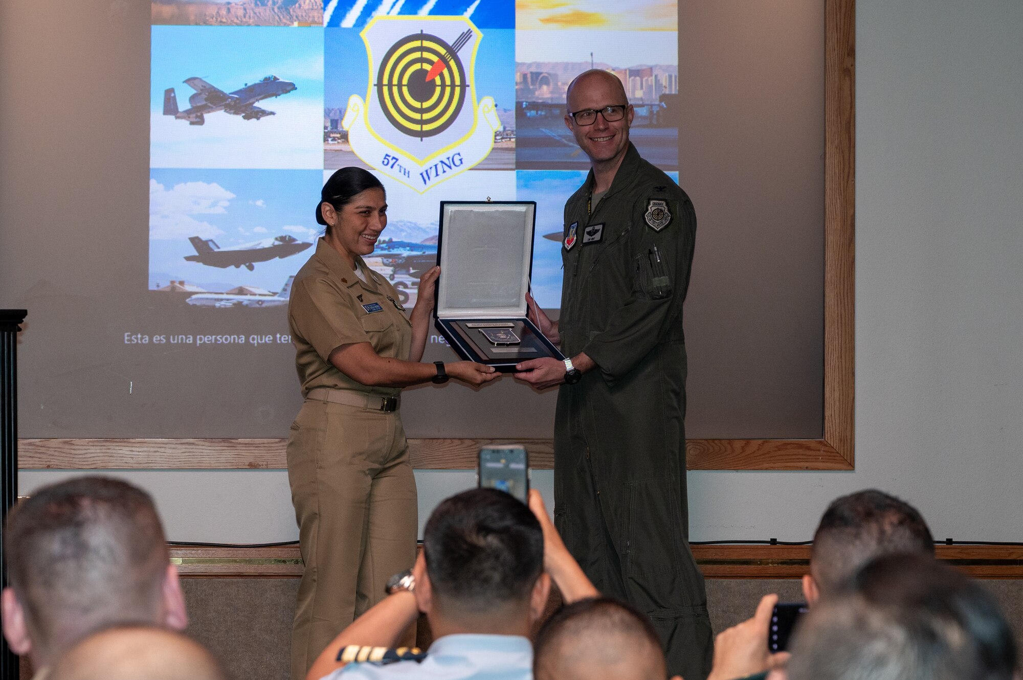 A man and a woman hold a plaque together.