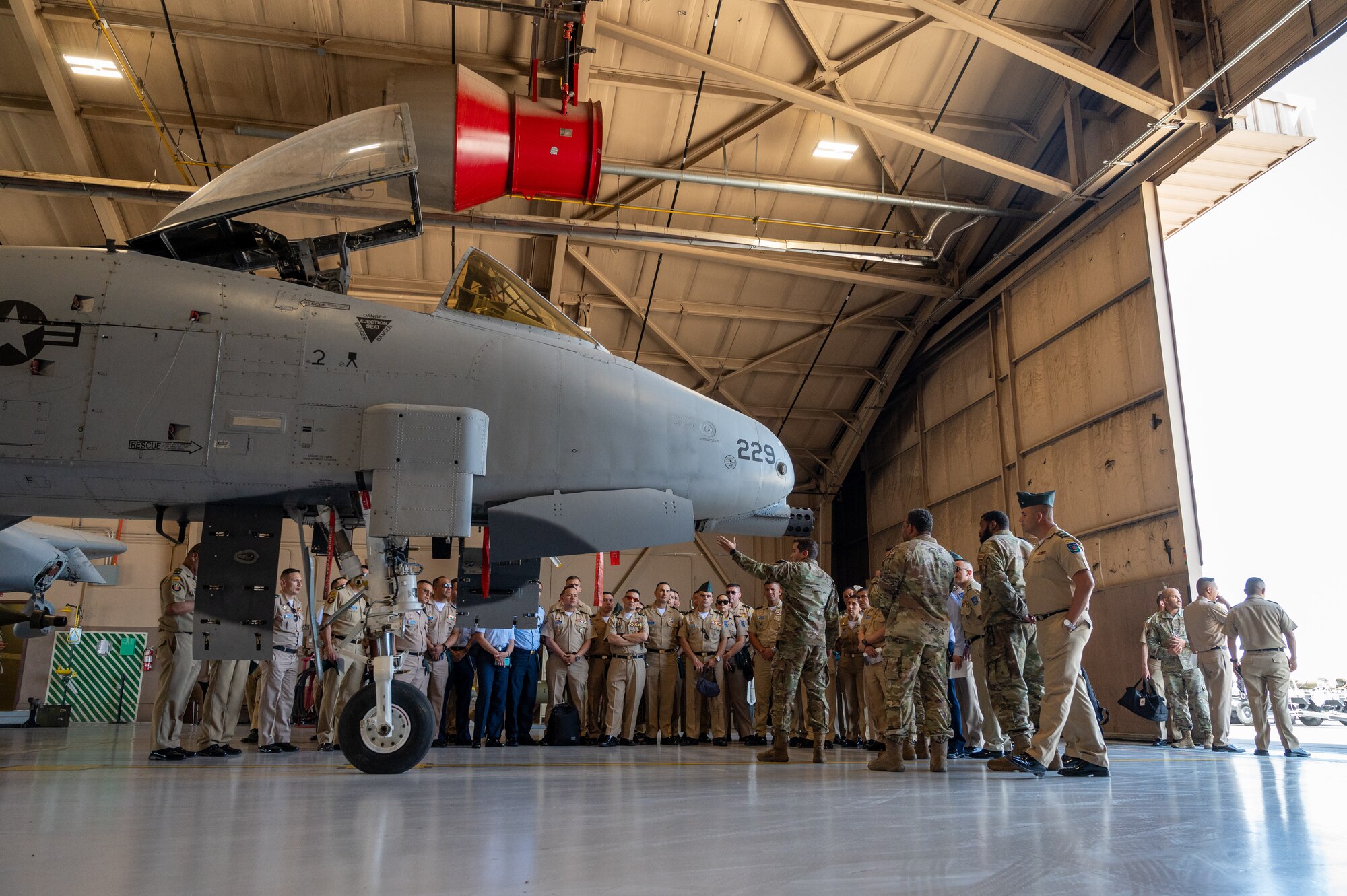 A group of U.S. Airmen and members of the Colombian armed forces stand next to an A-10 Thunderbolt II.