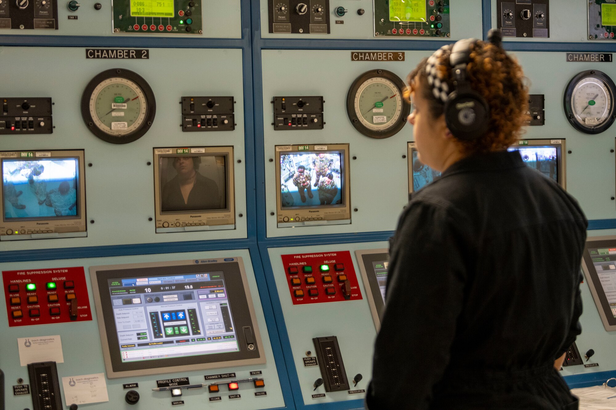 woman stares at monitors to make sure people are doing well in a hyperbaric oxygen chamber
