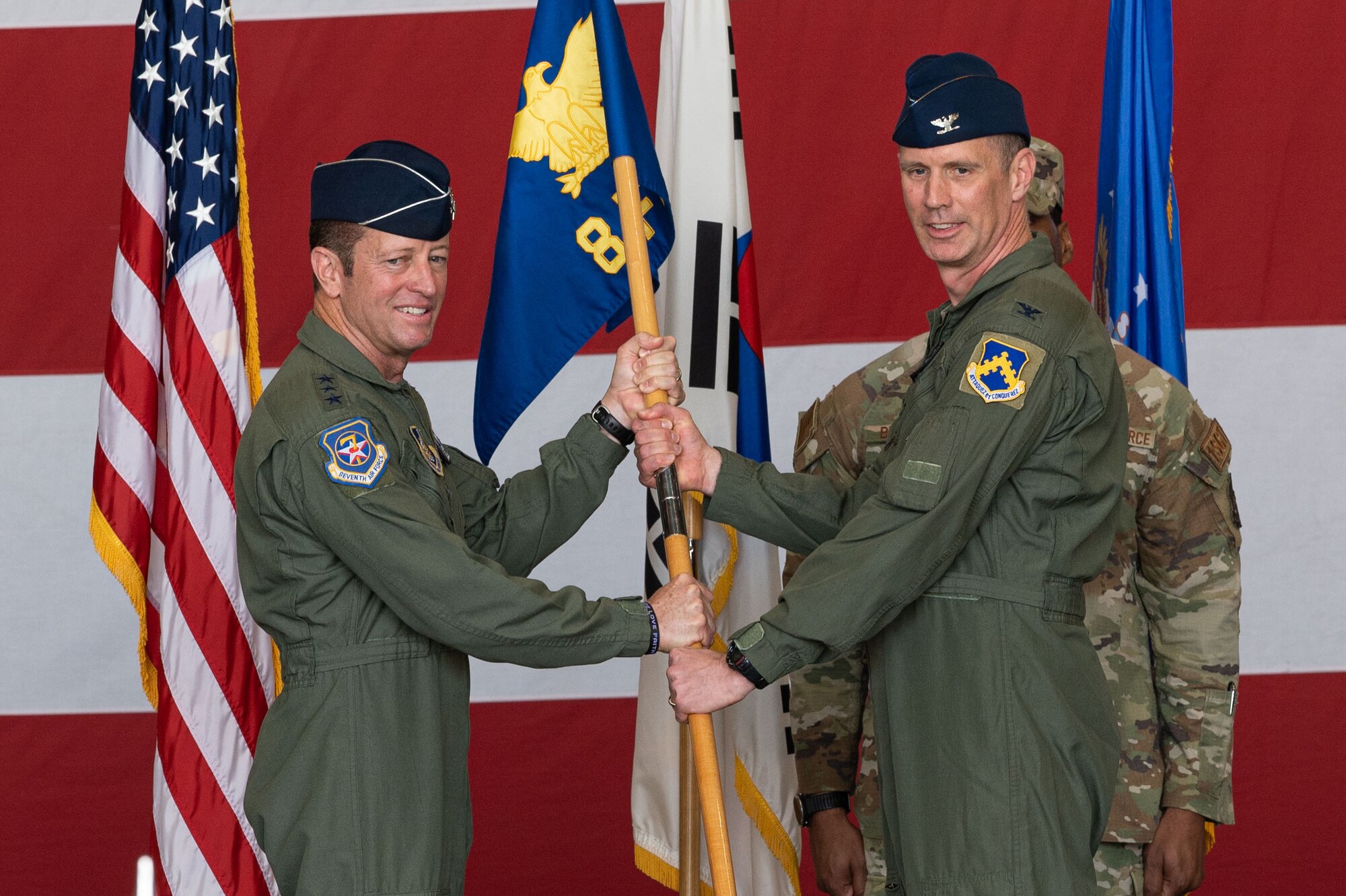 U.S. Air Force Lt. Gen. David Iverson, left, 7th Air Force commander, presents the 8th Fighter Wing guidon to Col. Peter Kasarskis, 8th FW incoming commander, during the 8th FW change of command ceremony.