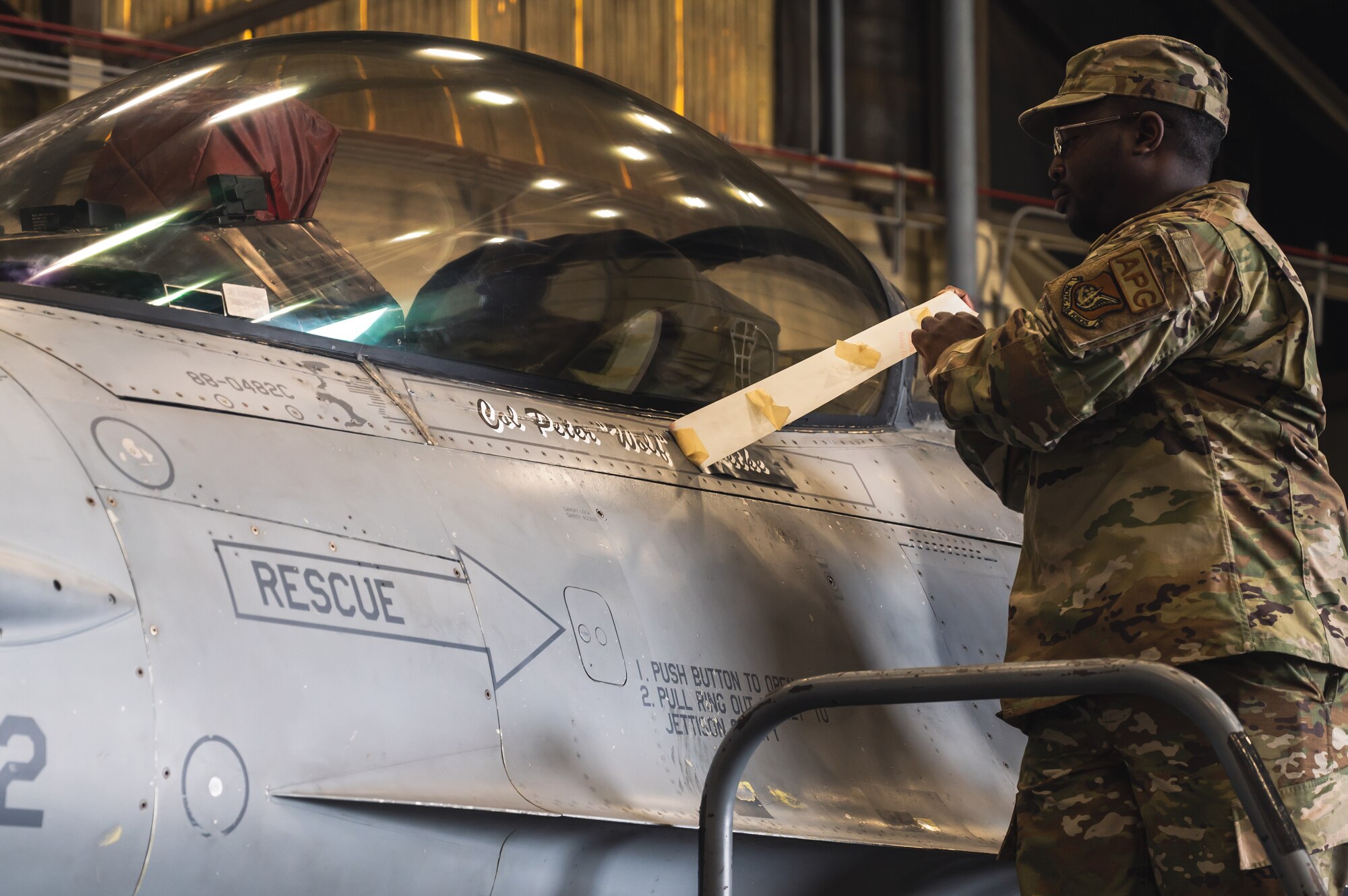 U.S. Air Force Staff Sgt. Javone Brown, 80th Fighter Generation Squadron F-16 crew chief, unveils the new 8th Fighter Wing commander, Col. Peter Kasarskis’s name on an F-16 during the 8th FW change of command ceremony.