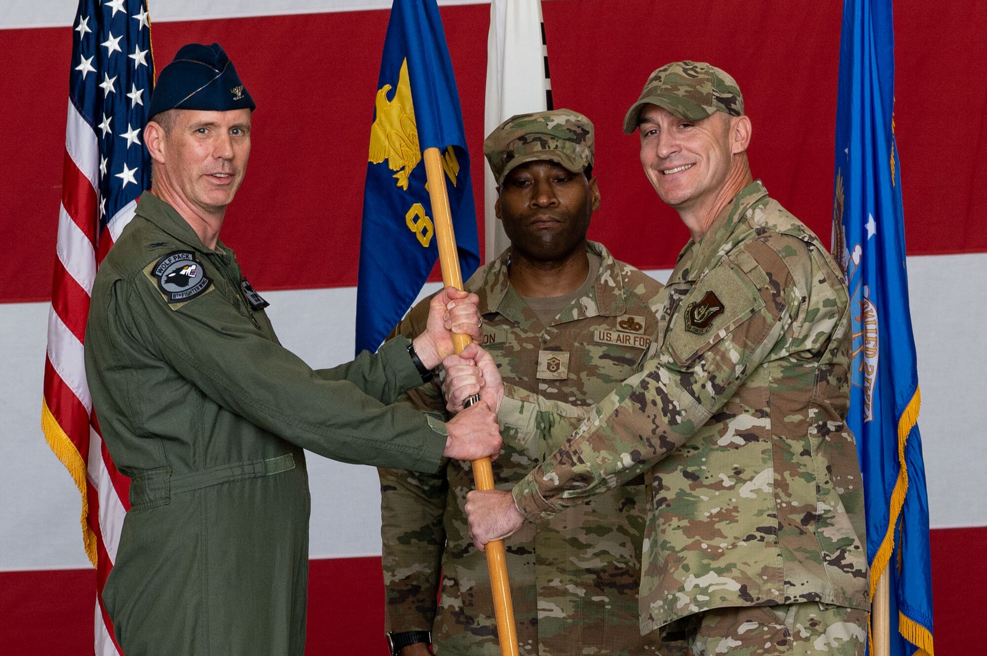 U.S. Air Force Col. Peter Kasarskis, 8th Fighter Wing commander passes the guidon to Chief Master Sgt. Nathan Chrestensen, 8th FW incoming command chief, during the 8th FW change of command ceremony.