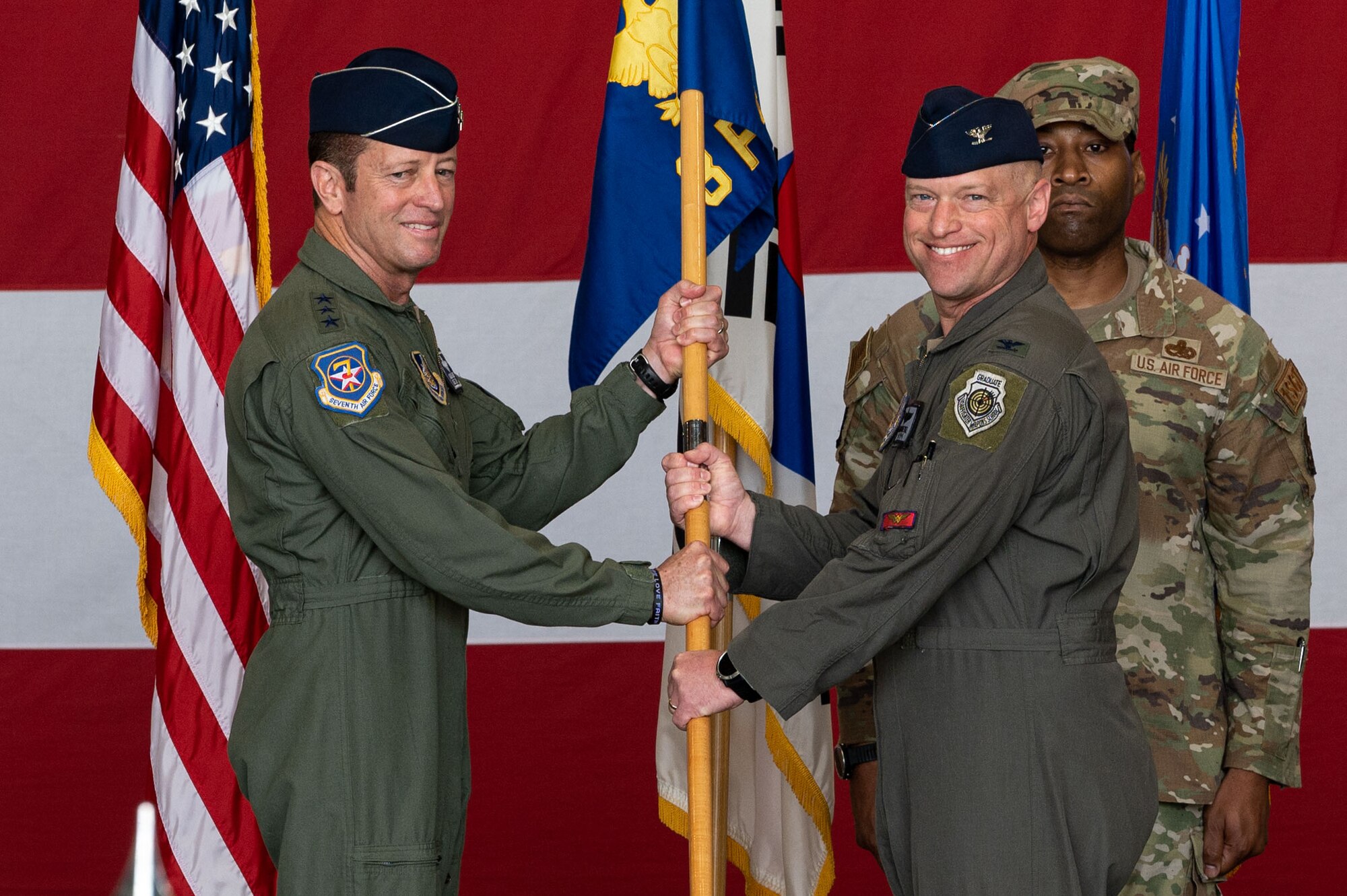 U.S. Air Force Lt. Gen. David Iverson, left, 7th Air Force commander, receives the 8th Fighter Wing guidon from Col. Matthew Gaetke, 8th FW outgoing commander, during the 8th FW change of command ceremony.