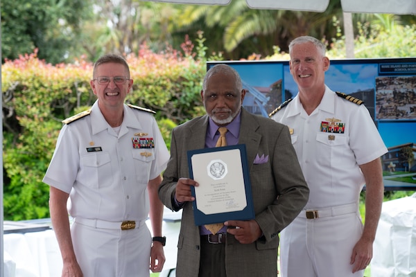 Vice Adm. Johnny Wolfe Jr., director of U.S. Navy Strategic Systems Programs (SSP) (left) presents a gift to Capt. Neil Sexton, Engineering Duty Officer (EDO) Schoolhouse commander (right), in honor of the school's fiftieth anniversary EDO School Thursday, June 6. SSP is the Navy command that provides cradle-to-grave lifecycle support for the sea-based leg of the nation's nuclear triad and for approximately 70 percent of the U.S.'s deployed strategic nuclear assets. EDOs supporting SSP are responsible to ensure the strategic weapon system is deployable and ready to support the vital strategic deterrence mission of America's Warfighting Navy. The EDO school-established in 1974 and founded by Naval Sea Systems Command Commander Vice Adm. Robert C. Gooding-provides education to improve the professional proficiency of EDOs through training in plans, programs, policies, and procedures that drive the life-cycle engineering of naval ships and systems. (U.S. Navy Photo by Lt. Jennifer Bowman/Released)