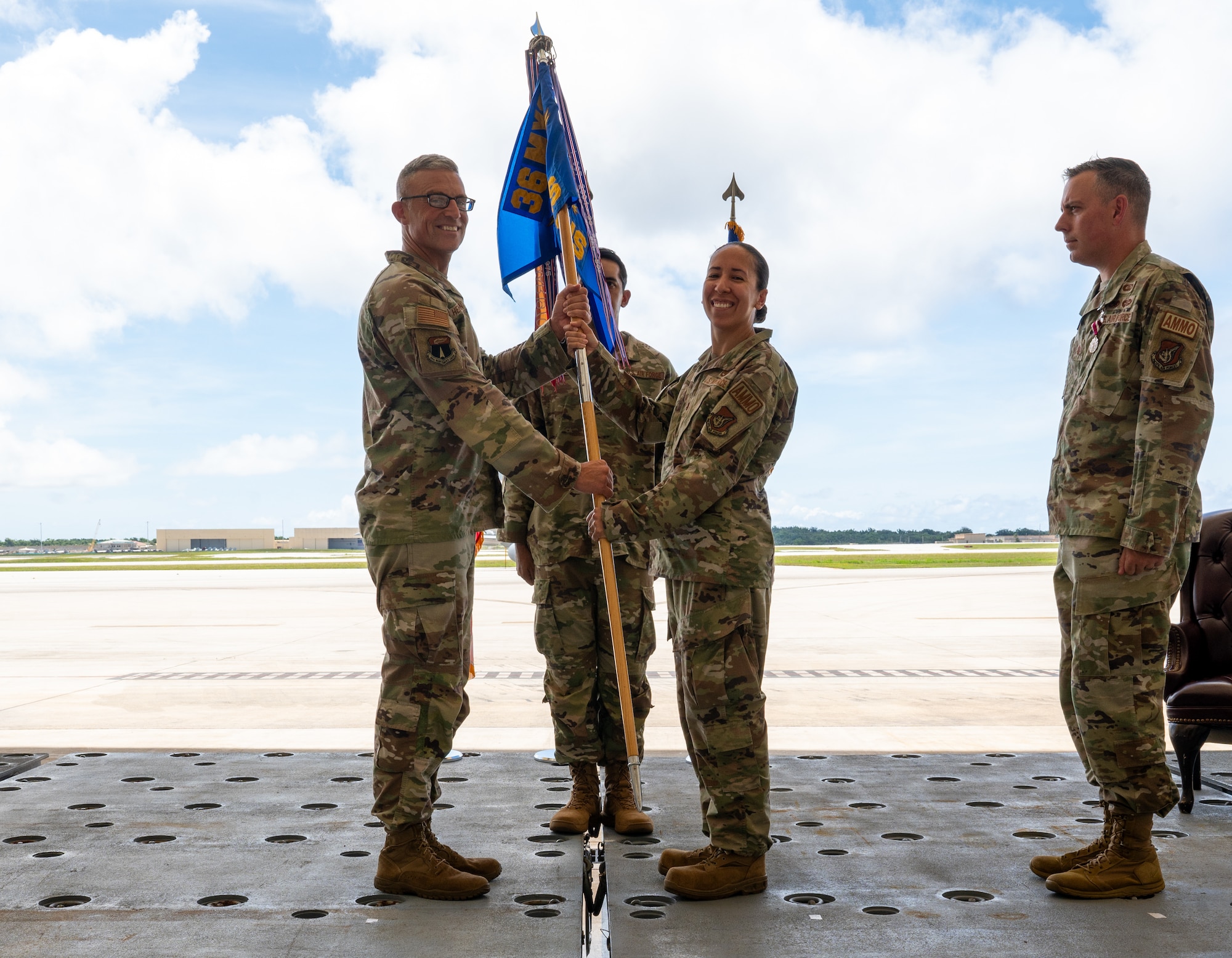 U.S. Air Force Col. James Hendrickson, 36th Maintenance Group commander, passes the guidon to incoming commander of the 36th Munitions Squadron Maj. Marisol Vierra, at Andersen Air Force Base, Guam, June 5, 2024. The passing of colors to commanders ensures the unit and its Airmen are never without leadership. (U.S. Air Force Photo by Airman 1st Class Manasseh Demissie)