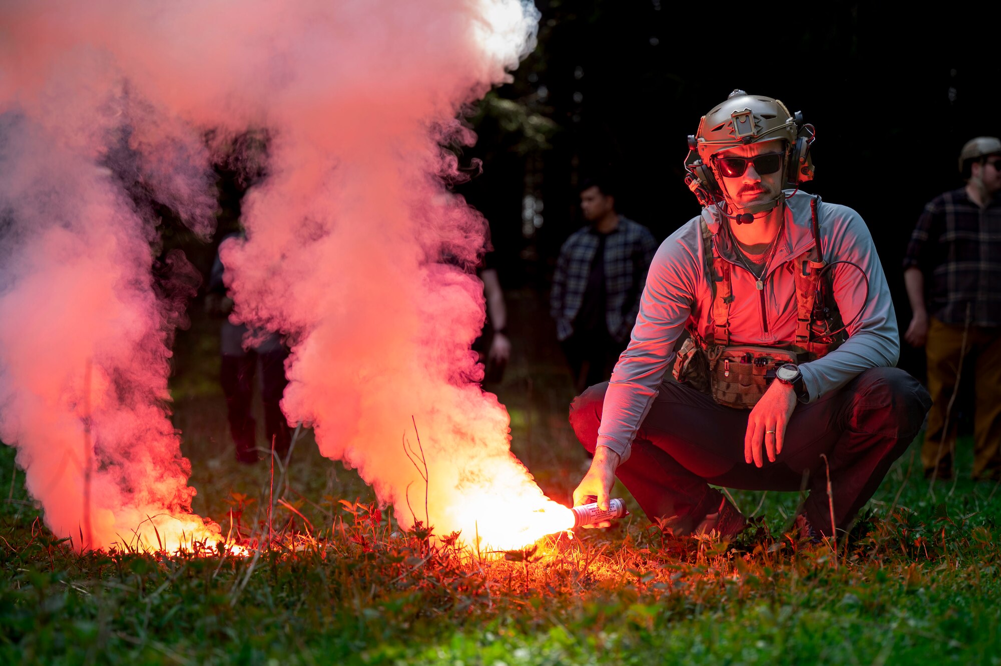 Rogers squatted, holding a lit flare.