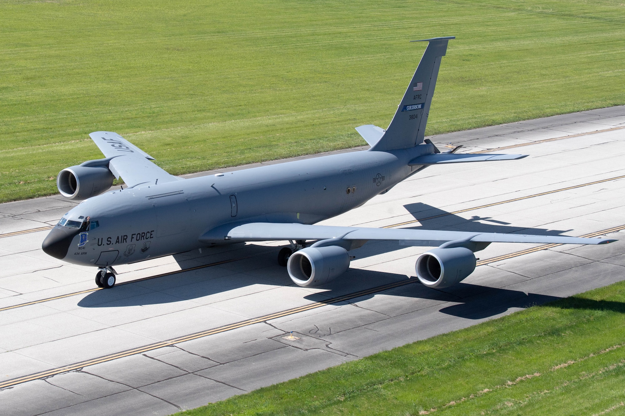 A KC-145R Stratotanker taxis on a runway. The photograph appears to be taken from a height significantly above the aircraft and runway.