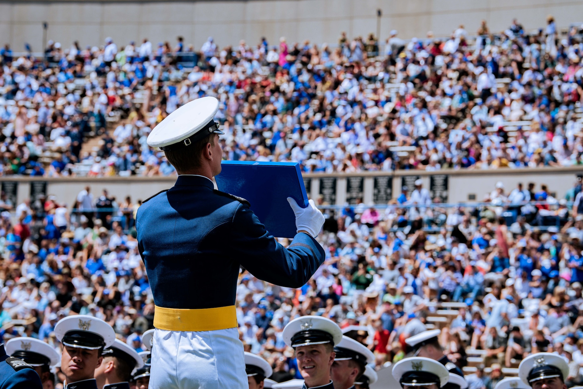A graduate holds up his diploma during a graduation ceremony
