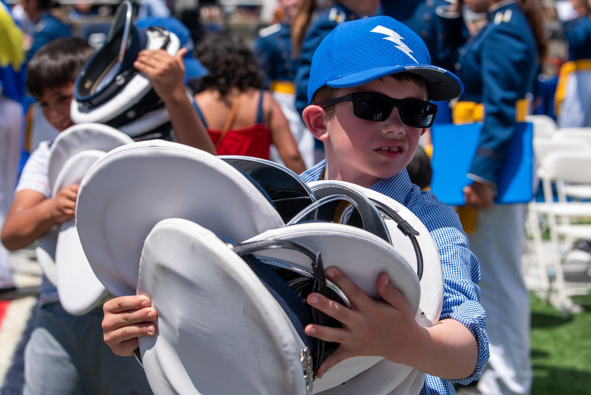Children collect graduate caps after the iconic hat toss during a graduation ceremony